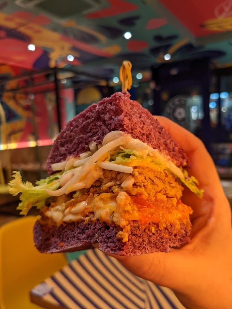 a hand holding a quarter of a flower burger flower burger